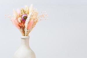 dried flowers and spikelets in ceramic bottle photo