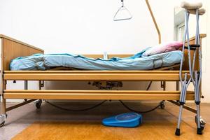 adjustable hospital bed and crutches at home photo