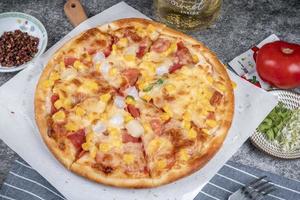classic pizza with cheese on the table in a cafe on a wooden stand with a cut triangular piece and a pizza knife photo