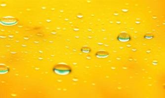 drops of water on yellow background photo