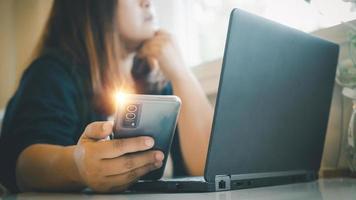 mujer sentado participación teléfono durante trabajo descanso curioso fuera de el ventana. trabajando mujer concepto, tecnología, ilimitado comunicación. con Copiar espacio foto