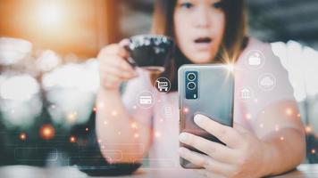 Asian woman checking financial information, banking, online shopping, credit card information via internet. A woman looks shocked when she sees her information in a trendy coffee shop. photo