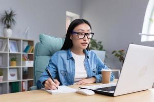 distancia aprendiendo. joven hermosa asiático hembra estudiante tomando un en línea examen foto