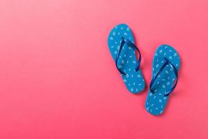Blue flip flops on pink background. Top view with copy space photo