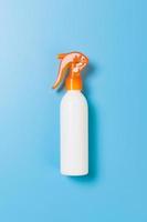 flat lay concept of summer travel vacation. Sunscreen bottle mock up on blue background top view with copy space photo