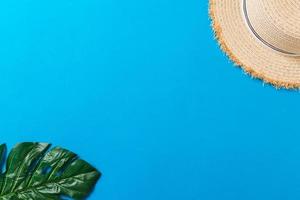 Beach accessories with straw hat on blue background top view with copy space photo