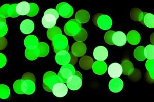 Unfocused abstract colourful bokeh black background. defocused and blurred many round green light photo