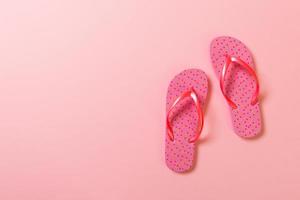 Coral flip flops on pink Background. Top view with copy space photo