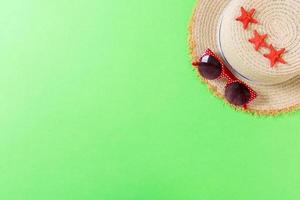 Beach hat with seashells on brown green table. summer background concept with copy space top view photo