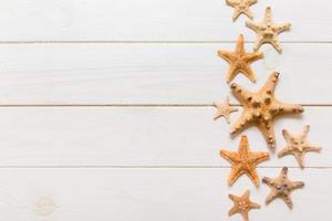 Top view of starfish and many seashells on white wood texture background top view. Copy space background, summer concept photo