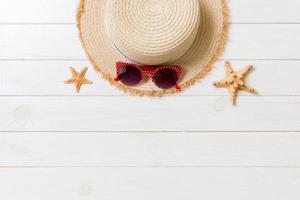 Straw hat, sunglasses and starfish On a white wooden background. top view summer holiday concept with copy space photo