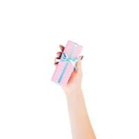 Woman hands give wrapped Christmas or other holiday handmade present in pink paper with blue ribbon. Isolated on white background, top view. thanksgiving Gift box concept photo