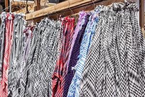 Traditional Keffiyeh or kefia hanging on hangers on bazaar in Egypt photo