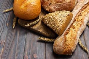 Homemade loaf of wheat bread baked on wooden background. top view with copy space photo