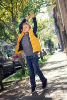 Playful boy catching bubbles on the street. photo