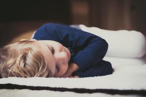 pequeño chico tomando un siesta en el dormitorio. foto