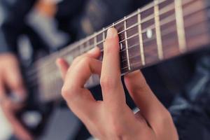 cerca arriba de hombre jugando eléctrico guitarra. foto