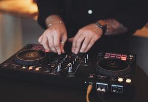 a DJ plays music on a controller at a party. photo