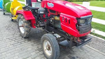 A tourist train pulled by a red tractor photo