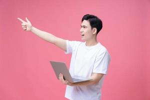 joven asiático hombre participación ordenador portátil en antecedentes foto