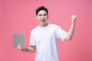 Young Asian man holding laptop on background photo