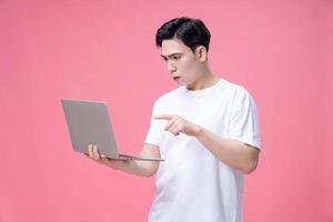 Young Asian man holding laptop on background photo