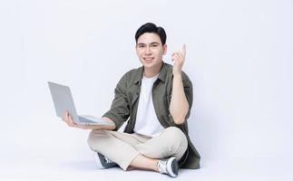 Young Asian business man sitting and using laptop on background photo