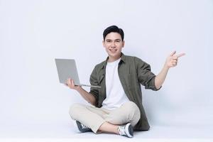 Young Asian business man sitting and using laptop on background photo