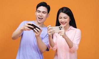 Young Asian couple using smartphone on background photo