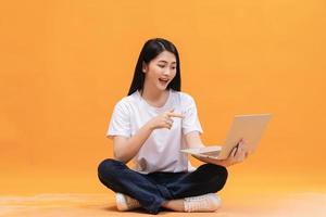 Young Asian girl using laptop on back ground photo