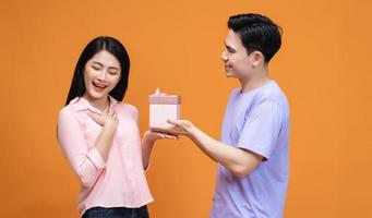 Young Asian couple with gift box on background photo