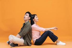 Young Asian couple sitting on background photo