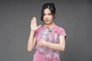 Young Asian woman holding empty bottle on background photo