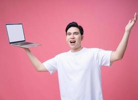 joven asiático hombre participación ordenador portátil en antecedentes foto