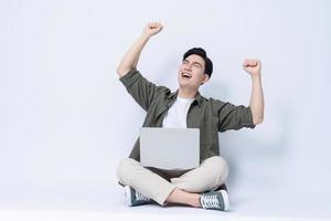 Young Asian business man sitting and using laptop on background photo