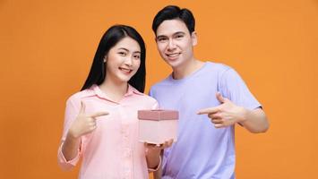 Young Asian couple with gift box on background photo
