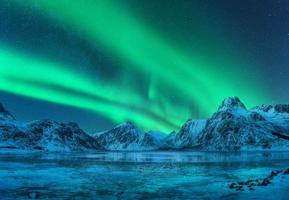 Aurora borealis terminado Nevado montañas, congelado mar costa foto