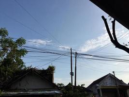 a view of intricate electrical poles and cables around densely populated housing photo