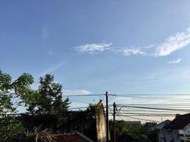 a view of intricate electrical poles and cables around densely populated housing photo