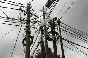 Tangled electric pole cables in cloudy weather conditions photo