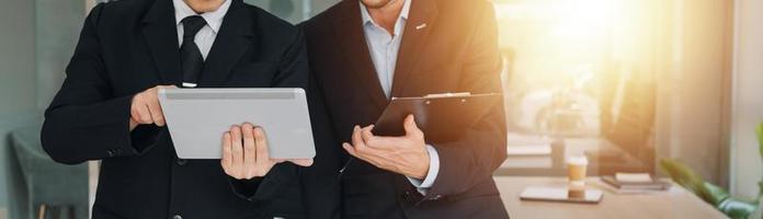 Financial analysts analyze business financial reports on a digital tablet planning investment project during a discussion at a meeting of corporate showing the results of their successful teamwork. photo