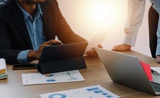 Financial analysts analyze business financial reports on a digital tablet planning investment project during a discussion at a meeting of corporate showing the results of their successful teamwork. photo