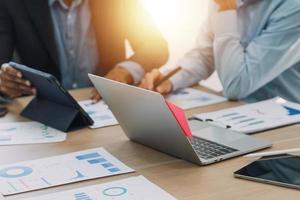 Financial analysts analyze business financial reports on a digital tablet planning investment project during a discussion at a meeting of corporate showing the results of their successful teamwork. photo