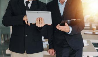Financial analysts analyze business financial reports on a digital tablet planning investment project during a discussion at a meeting of corporate showing the results of their successful teamwork. photo
