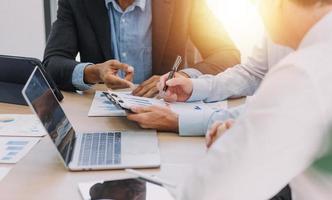 Financial analysts analyze business financial reports on a digital tablet planning investment project during a discussion at a meeting of corporate showing the results of their successful teamwork. photo