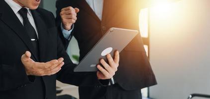 Financial analysts analyze business financial reports on a digital tablet planning investment project during a discussion at a meeting of corporate showing the results of their successful teamwork. photo
