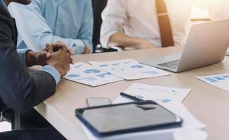Financial analysts analyze business financial reports on a digital tablet planning investment project during a discussion at a meeting of corporate showing the results of their successful teamwork. photo
