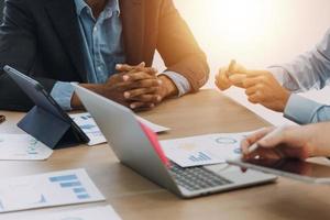Financial analysts analyze business financial reports on a digital tablet planning investment project during a discussion at a meeting of corporate showing the results of their successful teamwork. photo