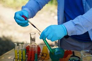 Close up hands wear blue gloves demonstrate science experiment about color chemicals substances in test tubes.  Concept, science subject, project work. Experiment, education photo