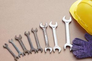 Wrenches, yellow helmet and gloves.  Concept, handyman or mechanic tools. Equipment for fixing or repairing, renovation in daily life. photo